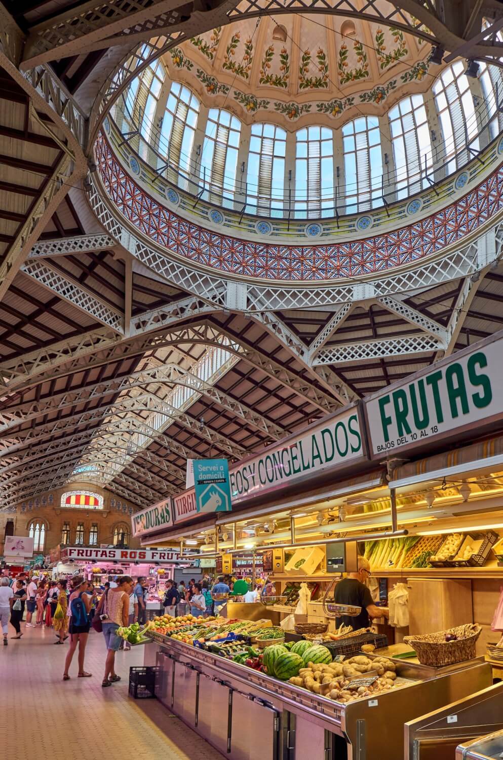 Indoor food market under a large decorative dome with stained glass windows