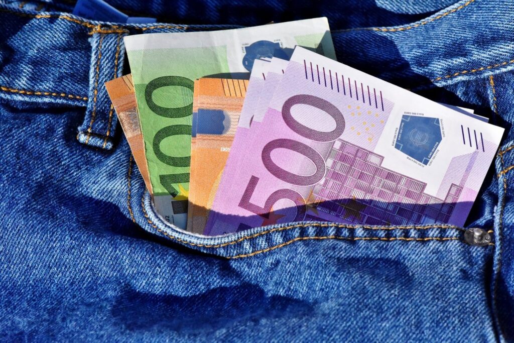 Euro bills sticking out of a jean pocket