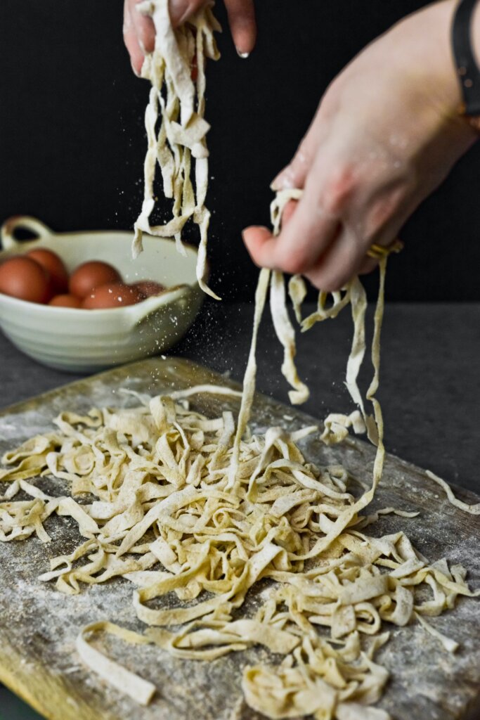 Raw pasta being made on a floured table