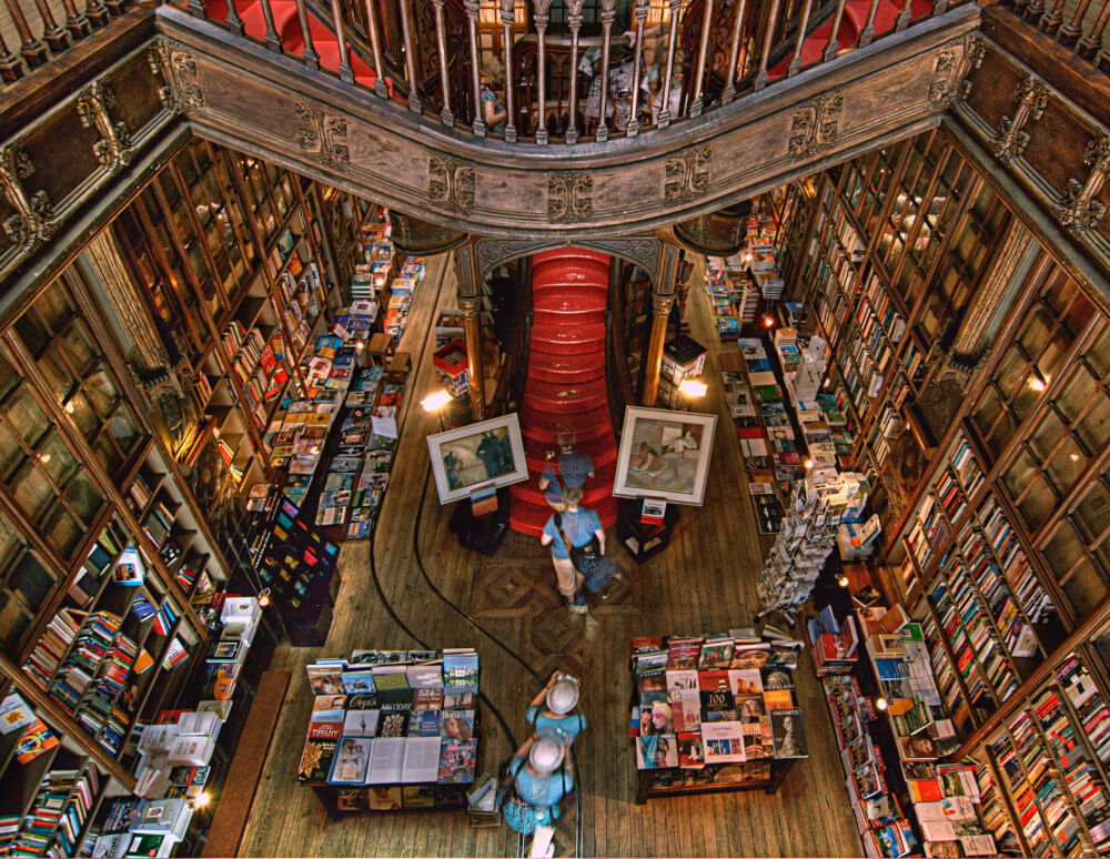 An ornately decorated wooden bookstore, with a red staircase in the center