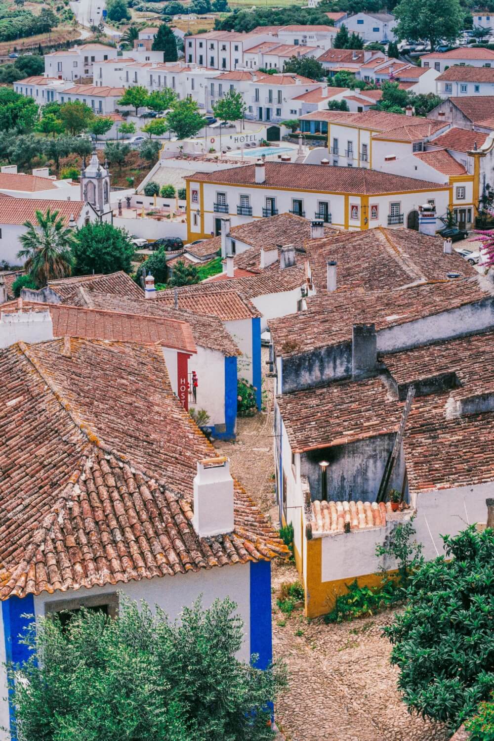 A photo small village from above with all white buildings and orange roofs