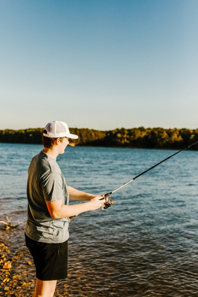 A young man fishing on a lake on a crisp Spring morning. 