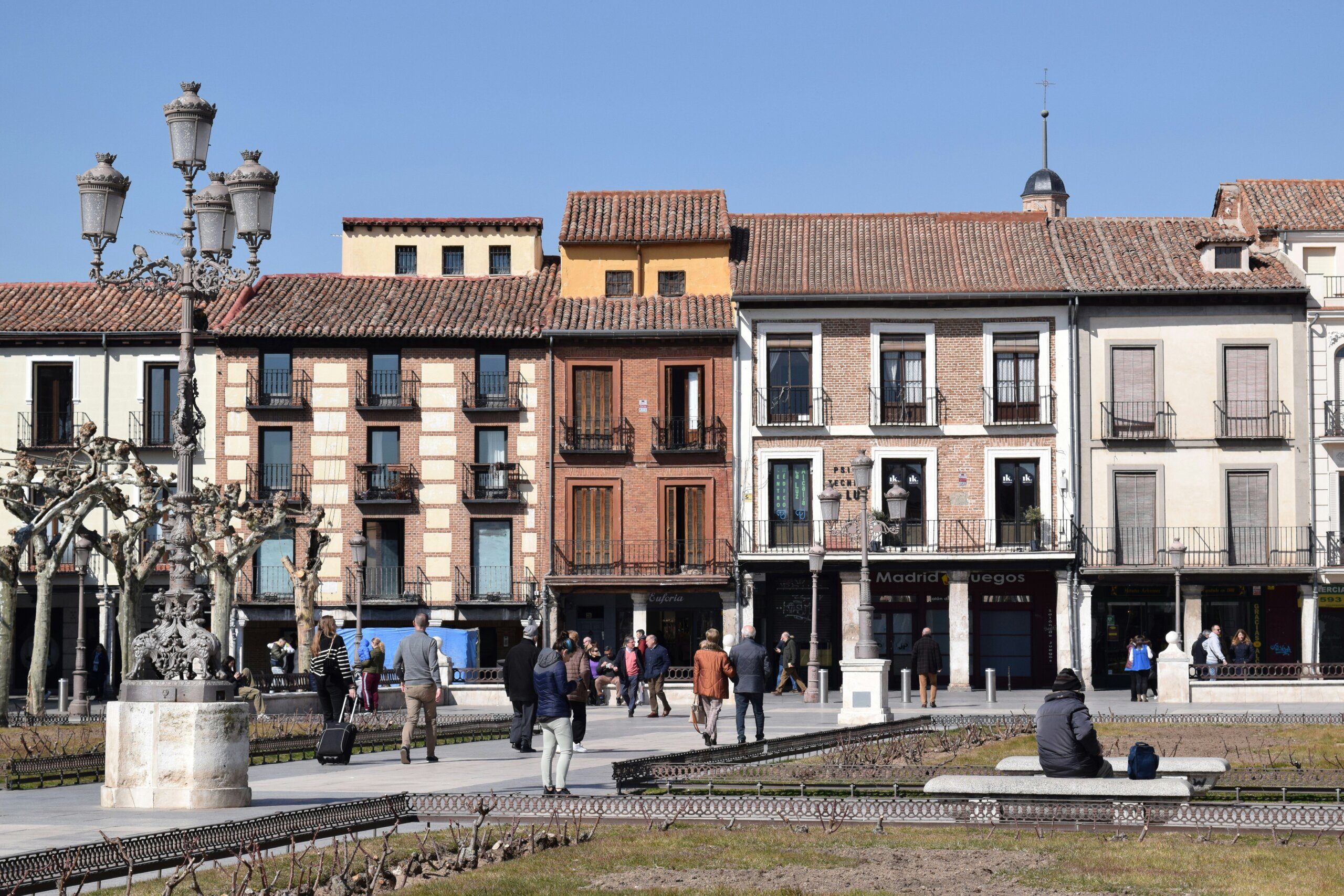 People walking in an outdoor plaza in a small town outside of Madrid 