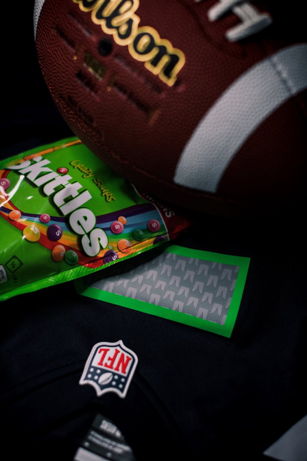 A Seattle Seahawks jersey and football. A pack of skittles is on top, which happens to be what fans would often see Marshawn Lynch eat on the sidelines. 