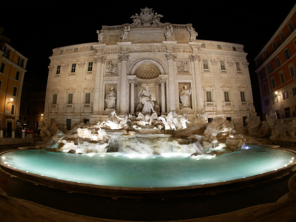 The Trevi Fountain in Rome illuminated at night.