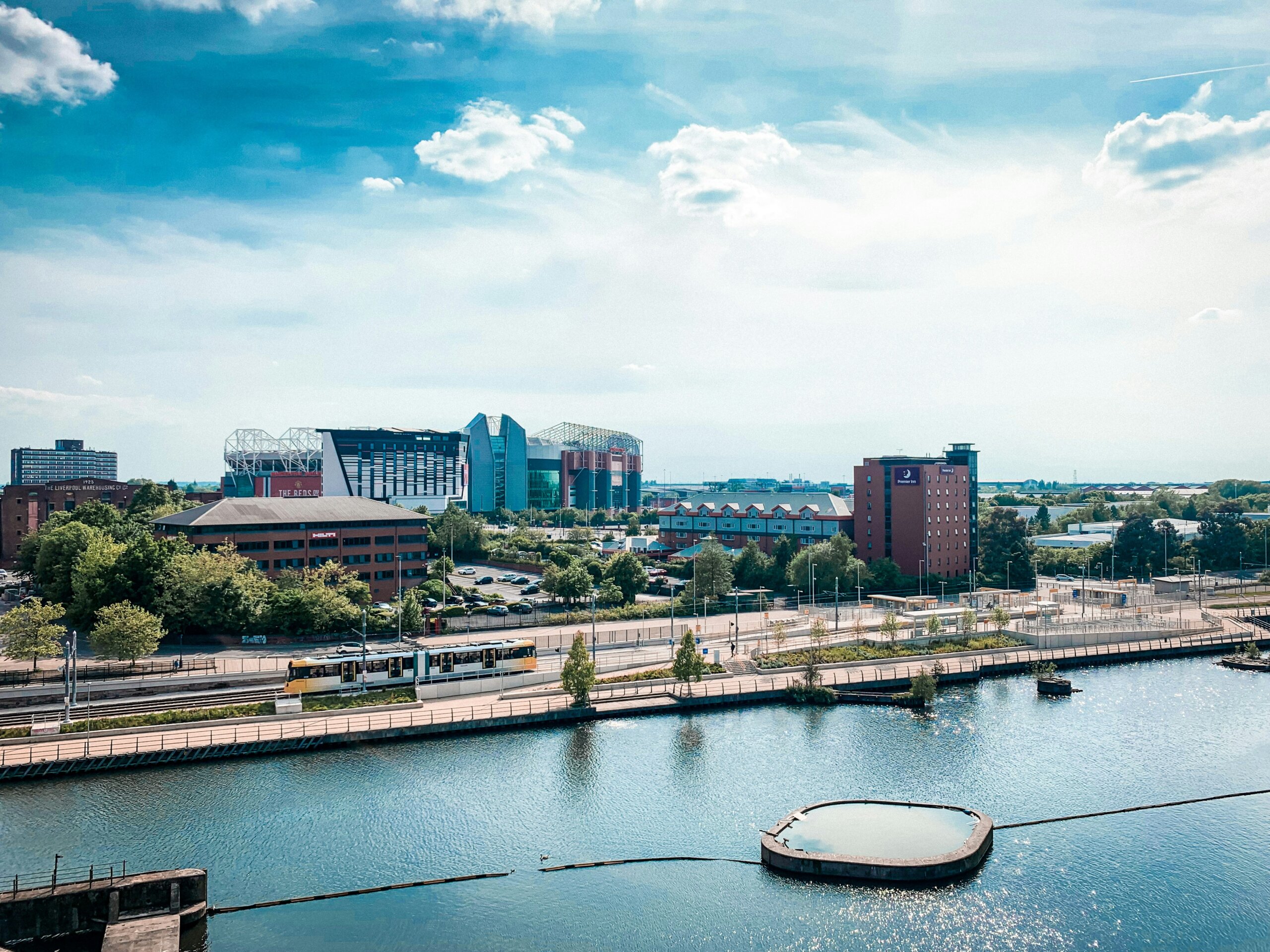 Salford Quays in Manchester with a Manchester yellow tram running in the distance